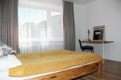 um quarto com uma cama, uma janela e uma cadeira em Naujai suremontuotas butas miesto centre. em Visaginas