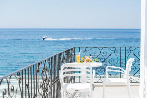 a table and chairs on a balcony overlooking the ocean at Samaria by the Sea in Khóra Sfakíon