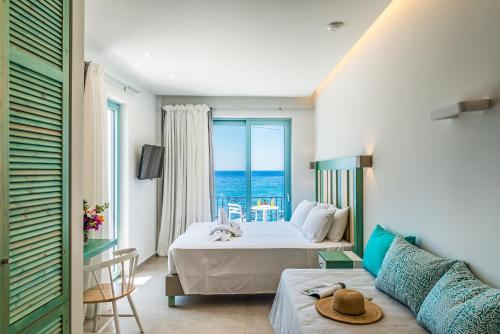 a bedroom with a bed and a view of the ocean at Samaria by the Sea in Khóra Sfakíon