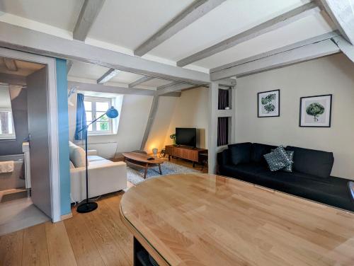 ein Wohnzimmer mit einem Sofa und einem Tisch in der Unterkunft CityCosy Strasbourg - Authentique Batelier in Straßburg