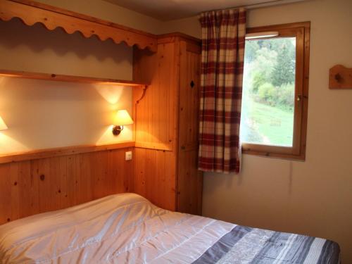 a bedroom with a bed and a window at Appartement Lanslebourg-Mont-Cenis, 3 pièces, 6 personnes - FR-1-508-234 in Lanslebourg-Mont-Cenis