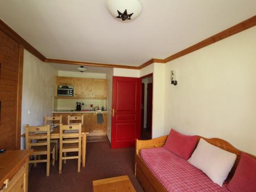 un salon avec un canapé rouge et une cuisine dans l'établissement Appartement 4 pers. pied des pistes avec piscine et parking, Lanslebourg-Val Cenis - FR-1-508-251, à Lanslebourg-Mont-Cenis