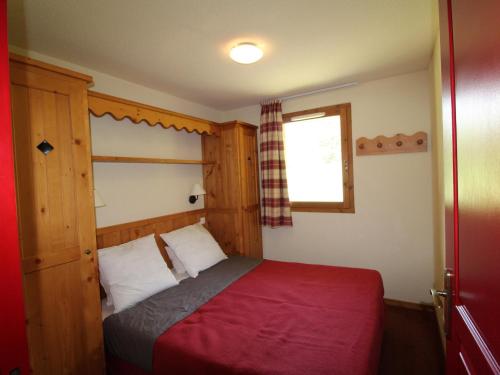 sypialnia z łóżkiem z czerwonym kocem i oknem w obiekcie Appartement Lanslebourg-Mont-Cenis, 2 pièces, 4 personnes - FR-1-508-251 w mieście Lanslebourg-Mont-Cenis