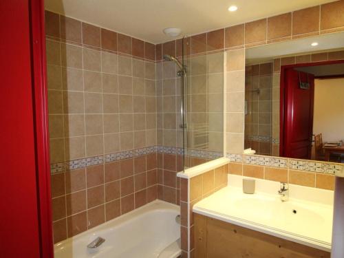 a bathroom with a tub and a sink and a mirror at Appartement Lanslebourg-Mont-Cenis, 2 pièces, 4 personnes - FR-1-508-251 in Lanslebourg-Mont-Cenis