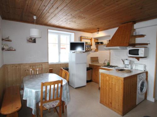 une cuisine avec une table et un réfrigérateur blanc dans l'établissement Appartement 5 personnes Val Cenis, 2 ch, draps fournis - FR-1-508-253, à Lanslebourg-Mont-Cenis