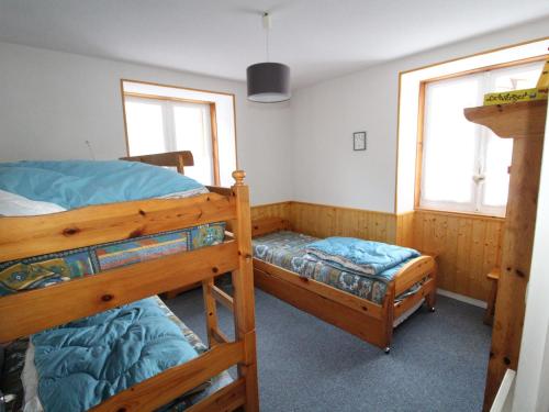 a bedroom with two bunk beds and two windows at Appartement Lanslebourg-Mont-Cenis, 3 pièces, 5 personnes - FR-1-508-253 in Lanslebourg-Mont-Cenis