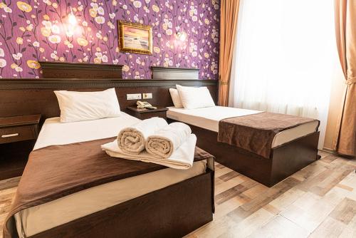 ガジアンテプにあるPamuk City Hotelの紫の壁のベッドルーム1室(ベッド2台付)