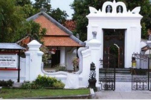 a white building with a gate in front of a house at Dee homes singaraja in Singaraja