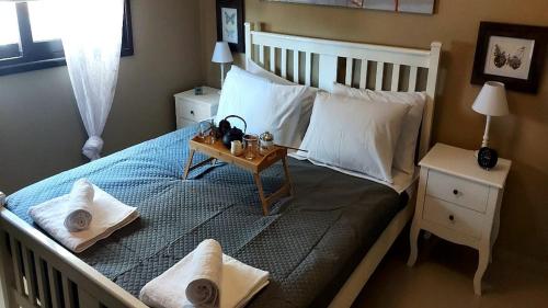 ein Bett mit zwei Kissen und einem Tablett darauf in der Unterkunft Paramount Gardens Resorts C202 in Larnaka