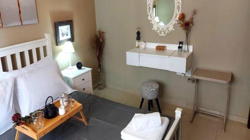 Schlafzimmer mit einem Bett, einem Tisch und einem Spiegel in der Unterkunft Paramount Gardens Resorts C202 in Larnaka