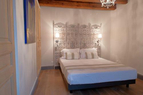 a bedroom with a white bed with a metal headboard at La Maison Debourg in Lyon