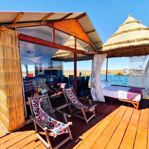 a deck with two chairs and a bed on a boat at TITICACA JALTAWI LODGE in Puno