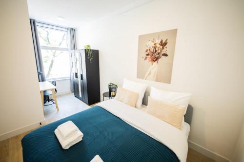 a bedroom with a large bed with a blue blanket at Admiringly 1 Bedroom Serviced Apartment 56m2 -NB306A- in Rotterdam