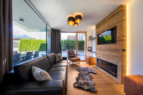 a living room with a leather couch and a fireplace at FamilienWohnung Wildspitze am Sonnenhang in Neukirchen am Großvenediger