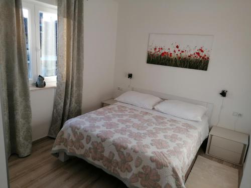 a bedroom with a bed and a painting on the wall at Apartment Nada 2 in Malinska