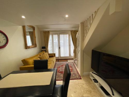 a living room with a couch and a tv at The old coach house 8 North lane in Kent