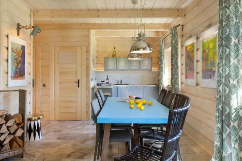 a dining room with a blue table and chairs at SeaUSasino - Luksusowe Drewniane Domy z Kominkami in Sasino