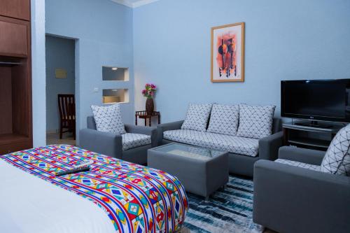 利伯维尔Hotel Hibiscus Blvd Triomphal的配有沙发和平板电视的客厅