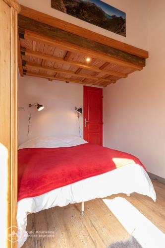 - une chambre avec un lit rouge et blanc dans l'établissement Roc de Burel, à Lanslevillard