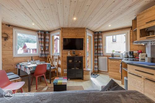 eine Küche und ein Wohnzimmer in einem Blockhaus in der Unterkunft Roc de Burel in Lanslevillard