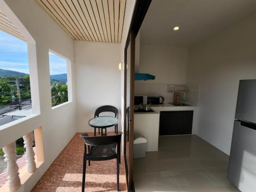 a kitchen with a table and chairs in a room at Hommory Residence - West Chalong in Ban Klang