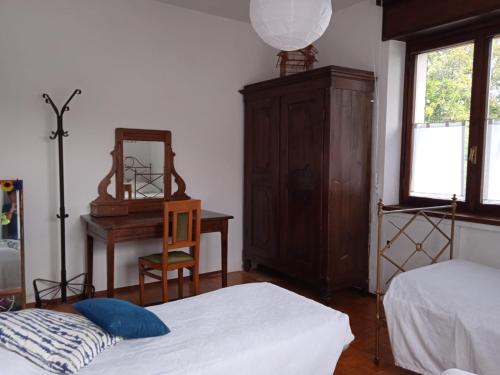 a bedroom with two beds and a dresser and a mirror at Appartamento Conca dei Rododendri in Trivero