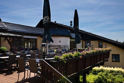 a restaurant with tables and chairs and umbrellas at Hotel Forstmeister in Schönheide