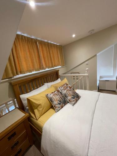 a bedroom with a large white bed with yellow pillows at The old coach house 8 North lane in Kent