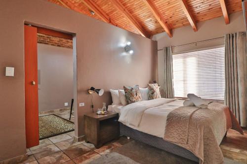 um quarto com uma cama grande e uma janela em Rudman Townhouses Self-catering Accommodation em Boksburg