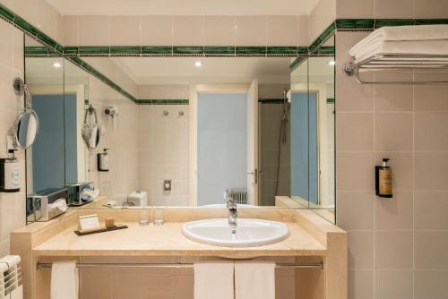 a bathroom with a sink and a large mirror at Parador de Teruel in Teruel