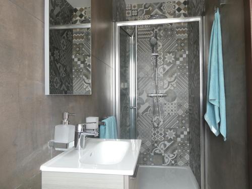 uma casa de banho com um lavatório e um chuveiro em Blue Sky Apartments em Mġarr