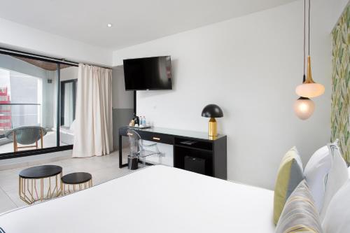 a room with a bed and a desk with chairs at Le Centell Hotel & Spa in Antananarivo