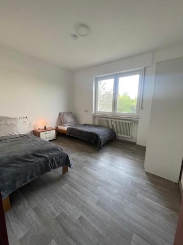 1 dormitorio con 2 camas y ventana en Ferien & Monteurwohnung in Bohmte-Hunteburg, en Bohmte