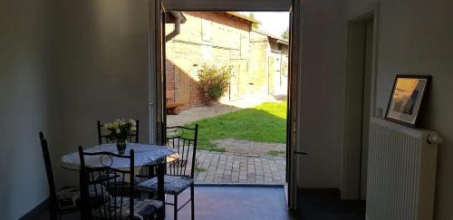 Zimmer mit einem Tisch, Stühlen und einer offenen Tür in der Unterkunft Ferienwohnung in Cottbus-Klein Ströbitz Nähe Badesee in Cottbus