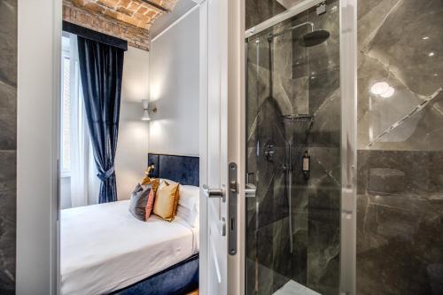 - une petite chambre avec une douche et un lit dans l'établissement Tree Charme Augusto Luxury Suites, à Rome