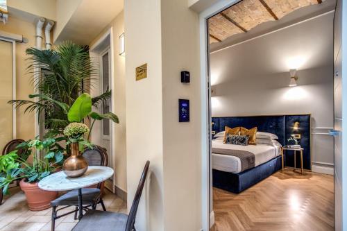 1 dormitorio con 1 cama, mesa y sillas en Tree Charme Augusto Luxury Suites en Roma