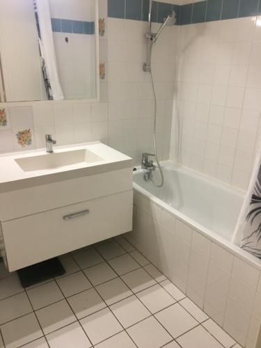 a white bathroom with a sink and a bath tub at Paris 13 New Modern Business Center in Paris