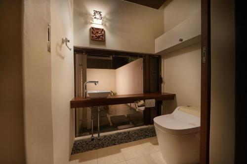 een badkamer met een toilet en een wastafel bij Private Villas Ryuz備瀬 in Motobu