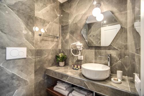 a bathroom with a sink and a mirror at Tree Charme Augusto Boutique Hotel in Rome