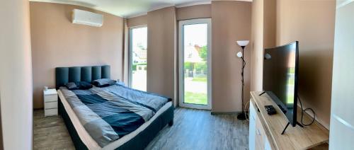 a bedroom with a bed and a large window at Finfera Villa in Balatonboglár