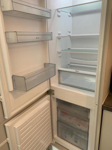 an empty refrigerator with its doors open in a kitchen at Luxury Modern Belfast City Centre 2 Bed Apartment in Belfast