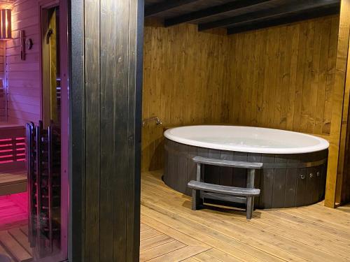 a room with a round bath tub with a bench in it at M-MAZURIA Domki letniskowe całoroczne MAZURY GIŻYCKO - z sauną i jacuzzi Fuleda in Fuleda
