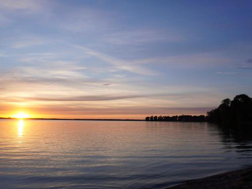 a sunset over a large body of water at M-MAZURIA Domki letniskowe całoroczne MAZURY GIŻYCKO - z sauną i jacuzzi Fuleda in Fuleda