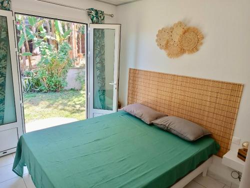 sypialnia z łóżkiem z zieloną kołdrą w obiekcie Les barbots w mieście Saint-Louis