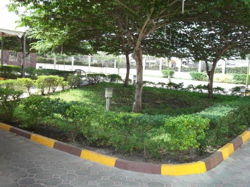 a park with trees and bushes and a sidewalk at Greenlight Hotel in Dar es Salaam