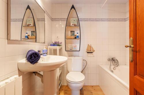 a white bathroom with a toilet and a sink at Casa en Montseny con piscina in Sant Pere de Vilamajor