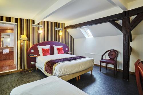 a hotel room with two beds and a chair at Hotel Opéra d'Antin in Paris