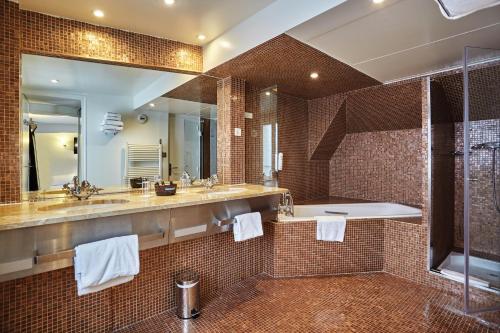 a bathroom with two sinks and a large mirror at Hotel Opéra d'Antin in Paris