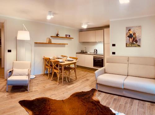 un soggiorno e una cucina con tavolo e divano di La Tsambra-Le Four des Alpes a Rhemes-Saint-Georges