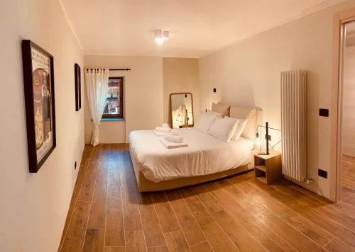 una camera con letto bianco e specchio di La Tsambra-Le Four des Alpes a Rhemes-Saint-Georges